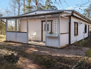 A small, single-story building with a covered porch and a window.