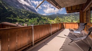 A wooden balcony with a view of a mountainous landscape. - Apartment Breithorn Grindelwald (Grindelwald)