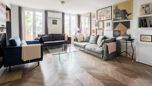Ein modernes Wohnzimmer mit einer Couch, einem Glastisch und einem Bücherregal.