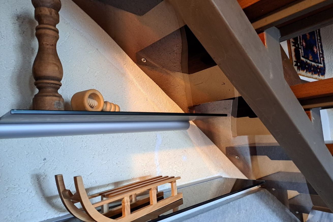 Una moderna scala con corrimano in legno e ringhiera in metallo.
