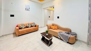 Un vaste espace de vie comprenant deux canapés, une table basse et un ventilateur de plafond.