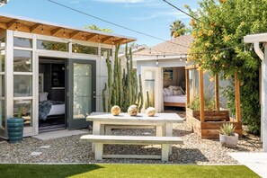 A modern house with a patio, a wooden pergola, and a garden with cacti and a palm tree. - House + Casita, Swim Machine, Heated Pool, Spa, Near Old Town Scottsdale (Scottsdale)