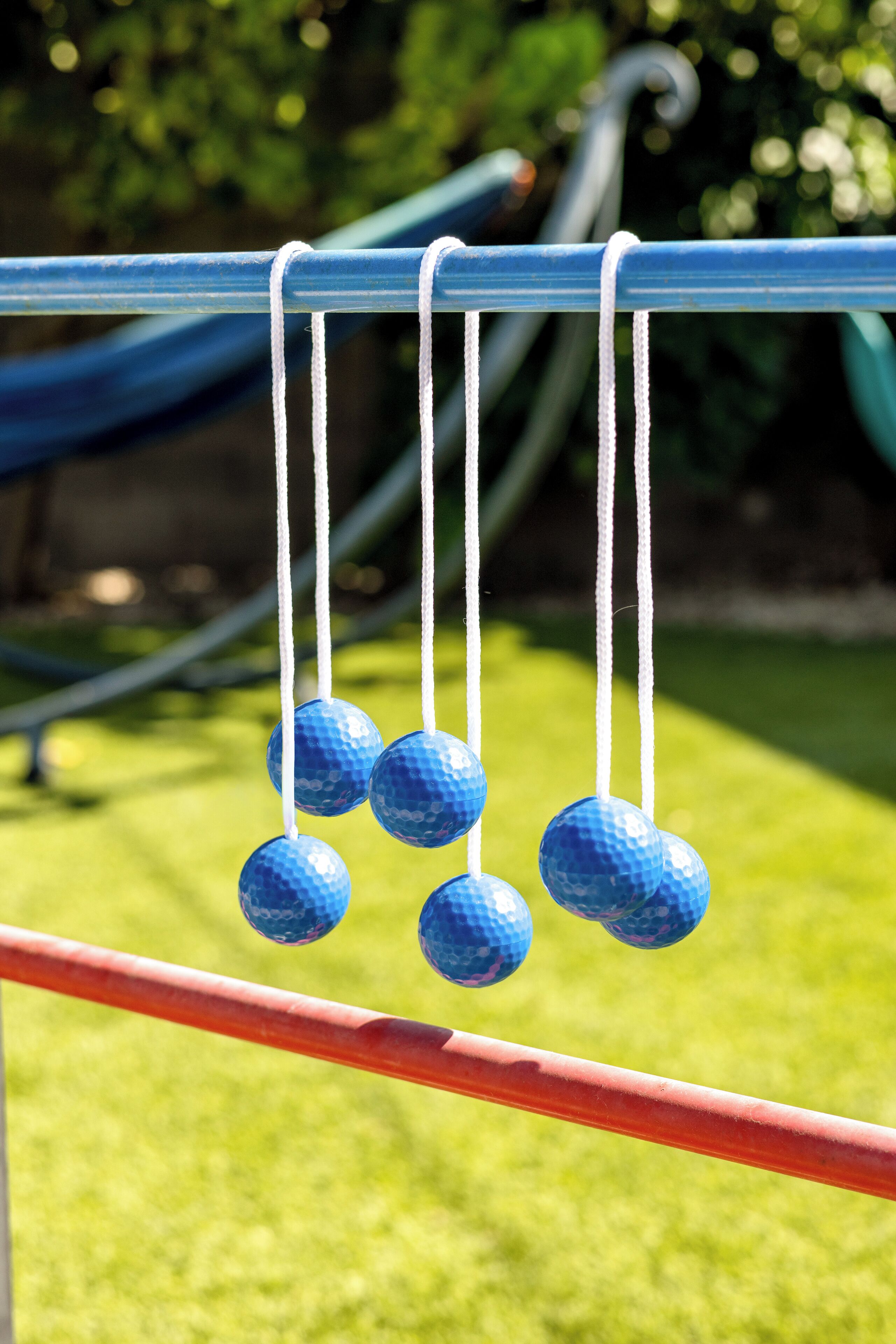 A close-up of blue golf balls hanging from a metal structure.