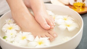 Feet in a bowl with water and white flowers. - Dubai Hotel (Da Nang)