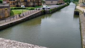 Un bâtiment historique doté d’une tour imposante et bordé d’un canal.