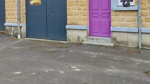 Un edificio con fachada de piedra, una puerta azul y una puerta morada.