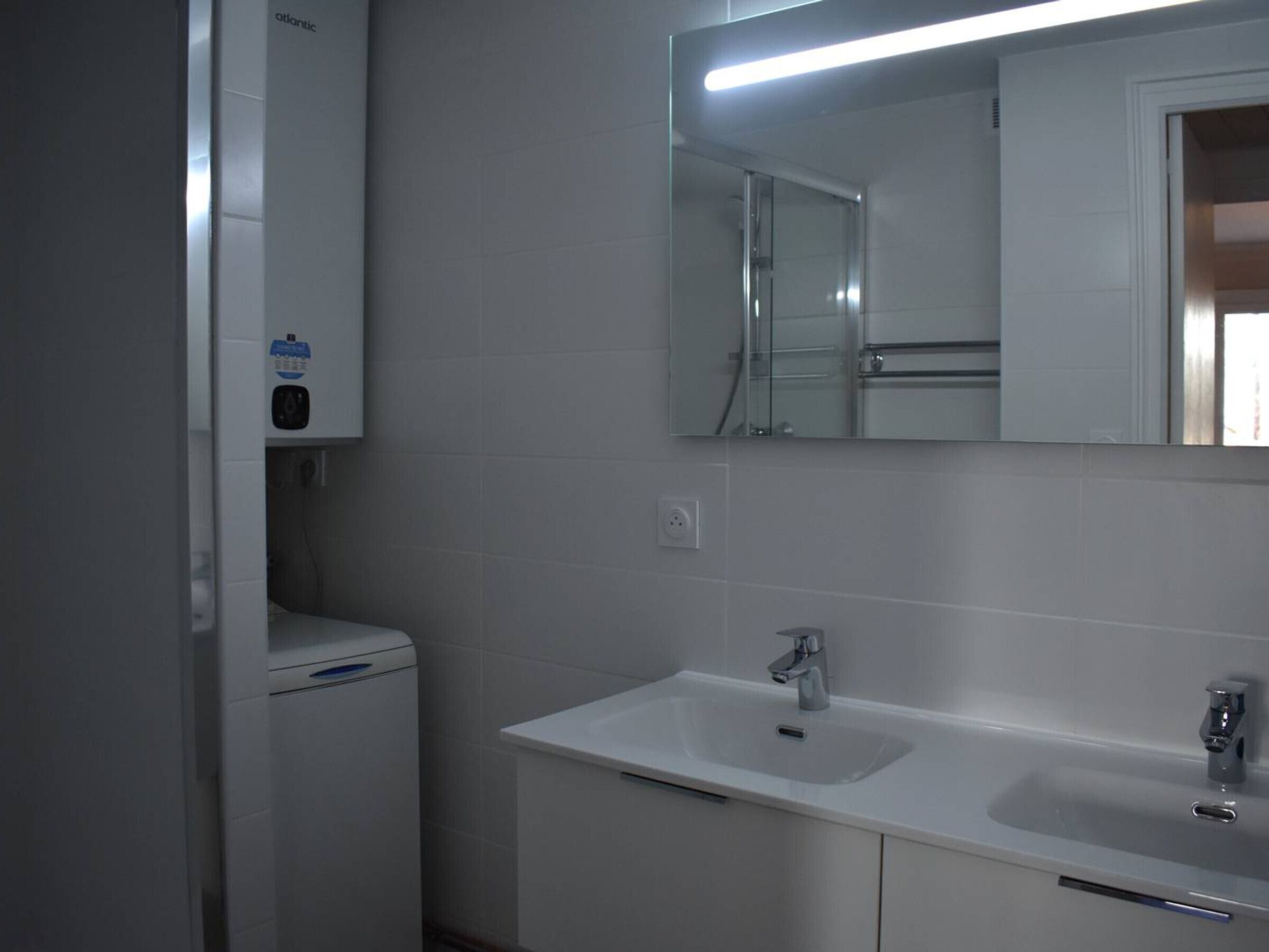 A bathroom with a white sink, a mirror, and a toilet.
