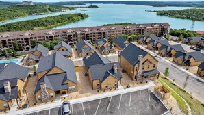 Ein Resort mit mehreren Holzhütten und einem großen Gebäude mit Balkonen mit Blick auf einen See.