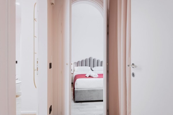 A bedroom with a bed, a bedside table, and a door.