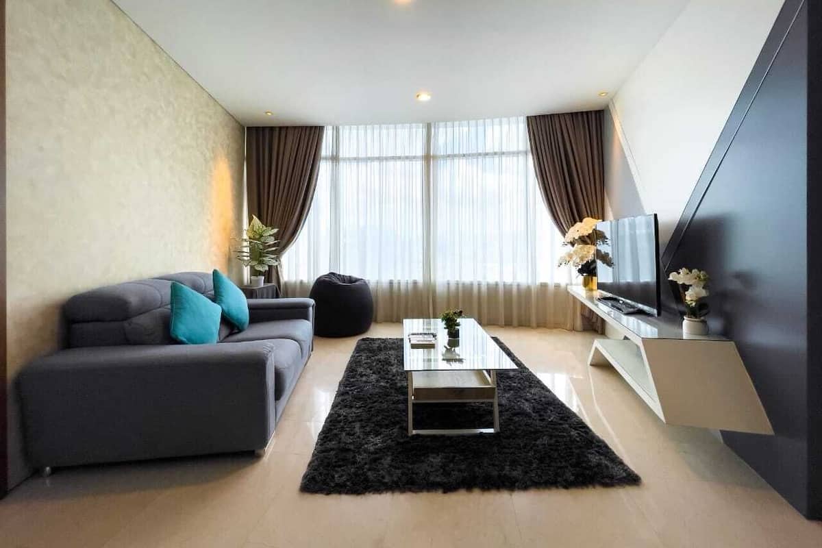 A modern living room with a sofa, a coffee table, and a TV on a stand.