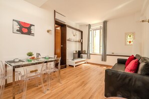 Ein moderner Wohnraum mit Essbereich, einer Couch und einer Treppe zu einer weiteren Ebene.