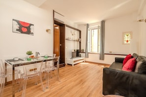 Ein moderner Wohnraum mit Essbereich, einer Couch und einer Treppe zu einer weiteren Ebene.