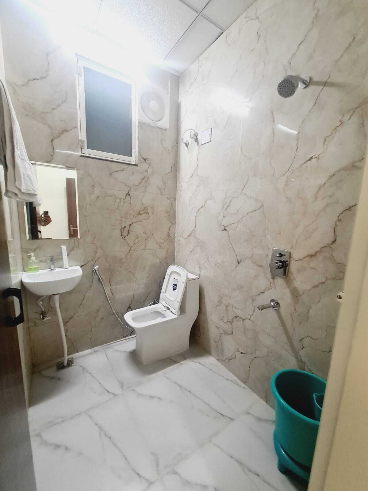 A bathroom with a toilet, sink, and shower.