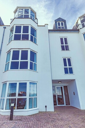A multi-story building with large windows and a corner entrance. - Modern, Dog friendly, 2 Bedroom Beach Front Apt. Central Newquay (Newquay Cornwall)