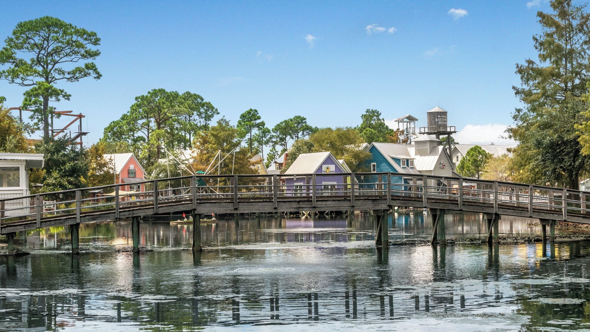 A wooden bridge over water with buildings on either side.