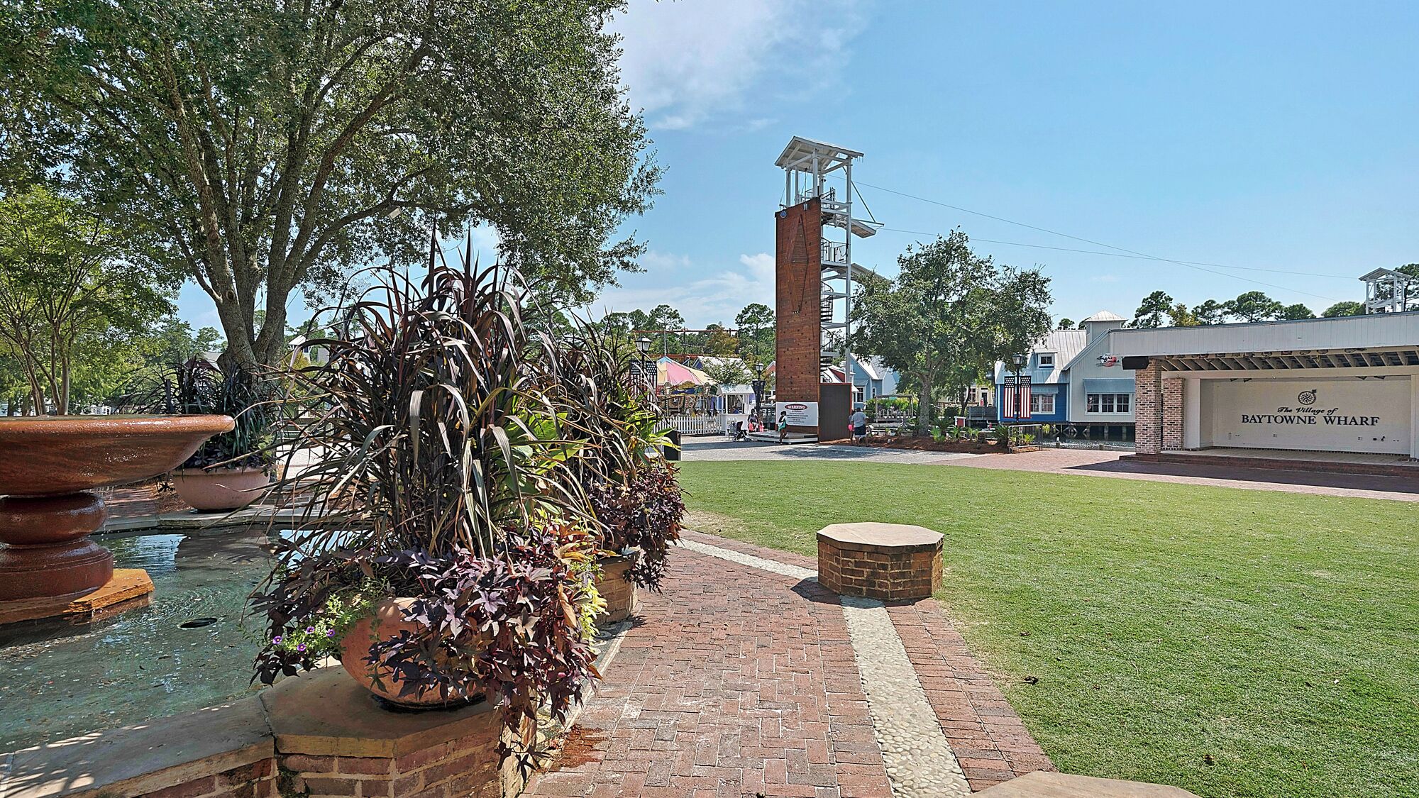 A brick pathway leading to a building with a sign reading "The Village of Baytown Wharfs".
