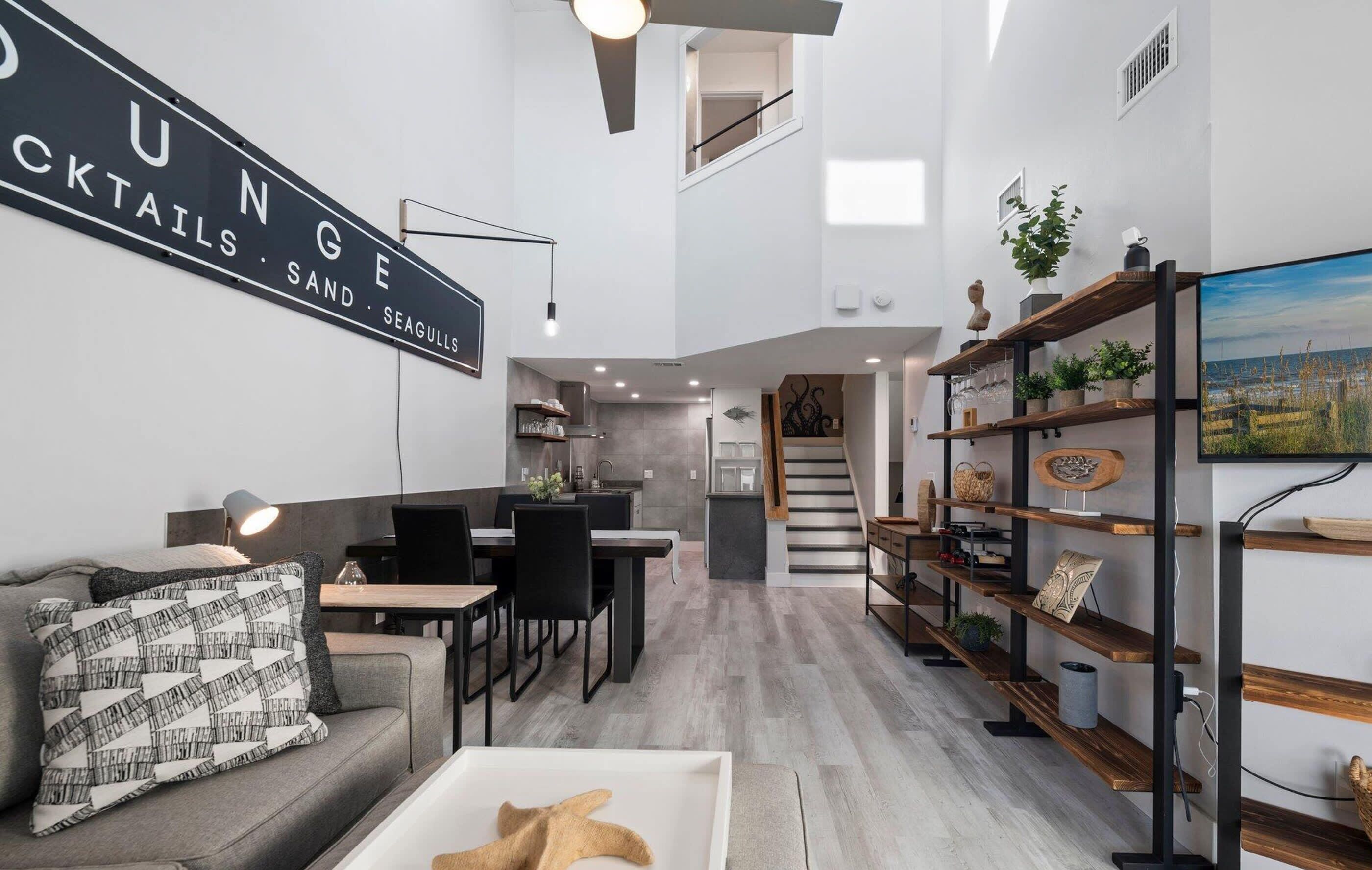 Modern living space with high ceilings and open kitchen layout.
