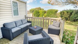 A deck with wicker furniture, including a sofa and two chairs, and a small table. - Bungalow, terrace, garden, 200m from the beach, by Groom*. (Guidel)