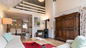 A modern living room with a sofa, a coffee table, a fireplace, and a cabinet. - Apartment with balcony in Veere | Buiten de Veste 36 (Veere)