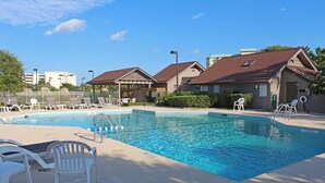 A swimming pool with lounge chairs and a covered pavilion. - Litchfield by the Sea - 3 BR Villa - View of Heron Marsh Lake (Pawleys Island)