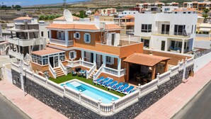 A modern hotel with a swimming pool, multiple balconies, and a view of the surrounding landscape. - Villa Naranja with private heated pool, sea views (Callao Salvaje)