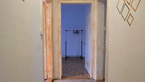A narrow hallway with wooden flooring, white walls, and a ceiling light. - Charming 2-bedroom apartment in vibrant Zürich with WiFi (Zürich)