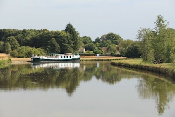Une rivière avec un bateau amarré sur la rive gauche.