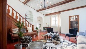 Un salón espacioso con una escalera de madera, un comedor y una cocina.