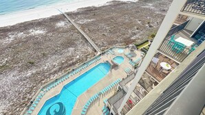 Ein Poolbereich mit mehreren Schwimmbecken und Liegestühlen, direkt neben einem Strand.