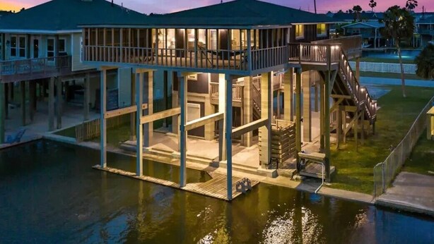 A waterfront property with a large deck, a pool, and a covered area. - Sea Isle Sailfish! Canal front in popular Sea Isle! Pet Friendly! (Galveston)
