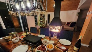Un espace repas équipé d’un barbecue, avec différents plats et une bouteille de vin.