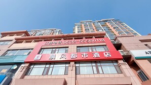 A hotel with a prominent red sign displaying the name and contact number. - Morning Wind Urban Hotel （May Fourth Square Branch) (Qingdao)