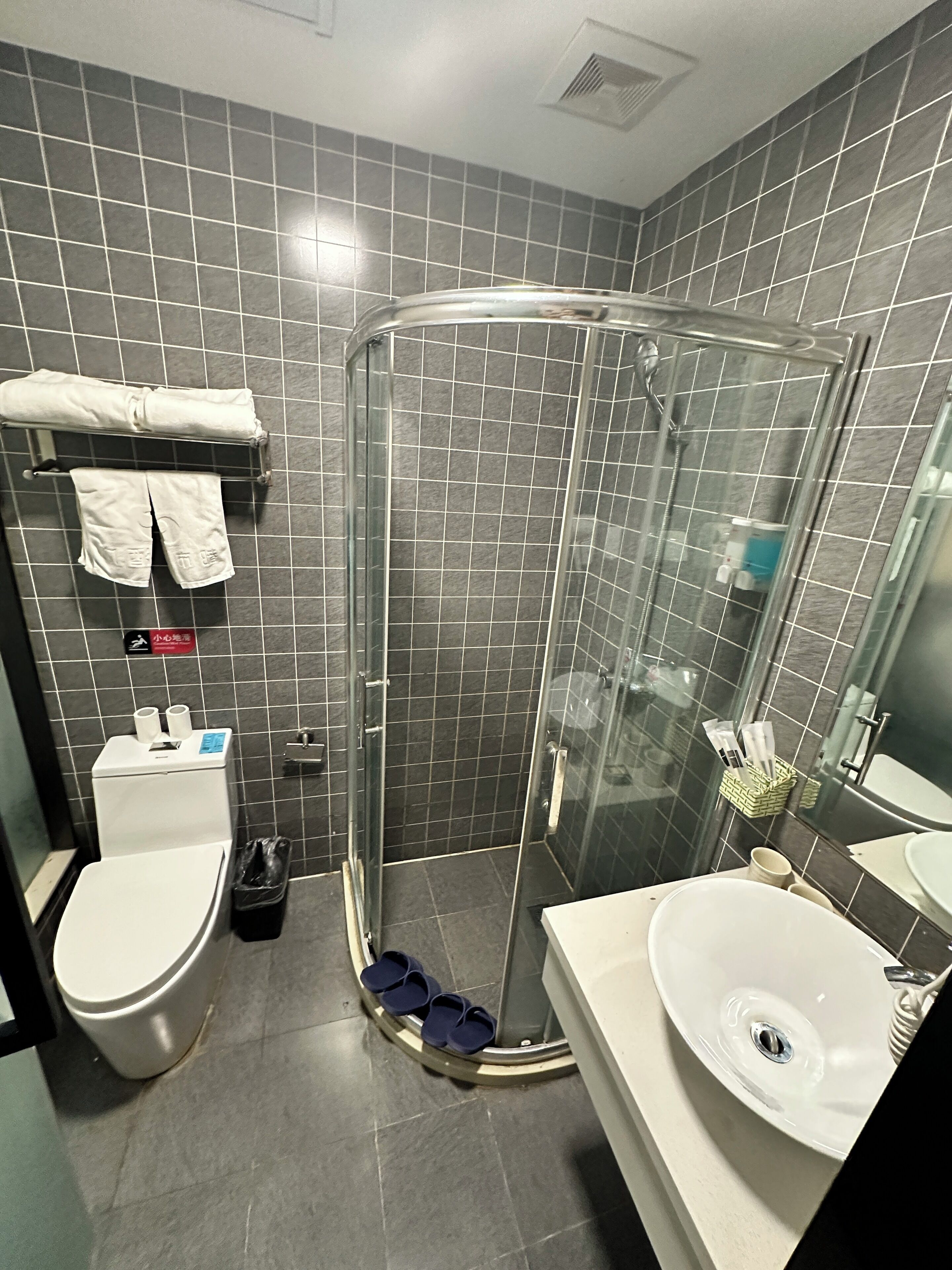Un baño moderno con ducha de vidrio, inodoro y lavamanos.