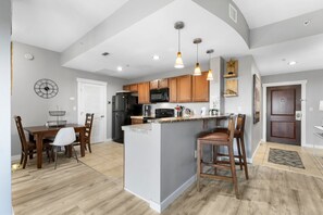 Une cuisine moderne avec des meubles en bois, un îlot central et des luminaires suspendus.