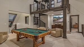 A pool table in a spacious room with a high ceiling and a staircase leading to an upper level. - Spacious + Spectacular + Views | Aspen Glade Retreat (Beaver Creek)