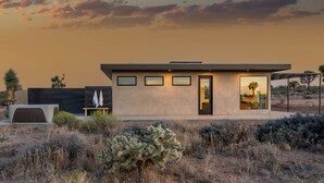 Un edificio moderno con techo plano, ventanas grandes y una puerta.