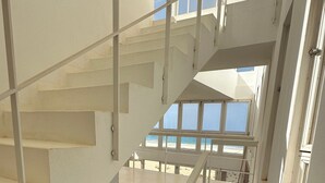 A multi-level staircase with blue steps and white railings, leading to a balcony with a view of the beach. - 4 Bedroom Private vacation home in Vila do Maio (Vila do Maio)