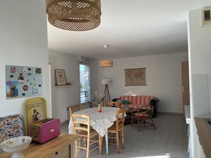 A dining area with a table, chairs, a basket, a toaster, and a wall with a map and decorations. - Chez Pia, apartment with swimming pool (Poitiers)