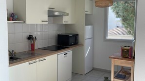 A compact kitchen with a microwave, toaster, and dishwasher.