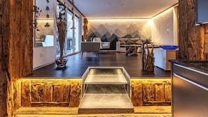 Een modern interieur met een wand van hout, een eethoek en een keuken met een blauwe kom.