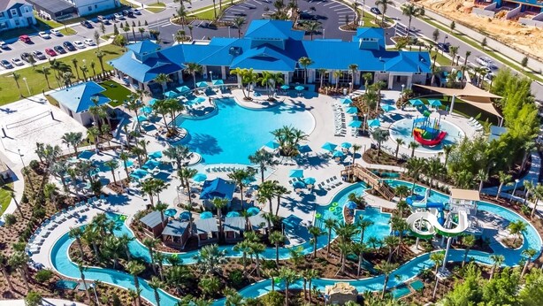 A resort with multiple swimming pools, palm trees, and a large building with a blue roof.
