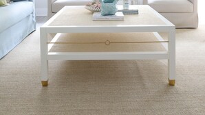 Una sala de estar con una mesa de centro blanca, dos sillones y un sofá.