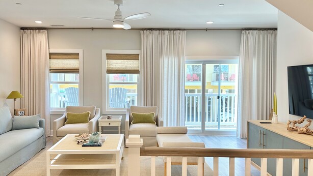 Una sala de estar moderna con un sofá, sillones, una mesa de centro y un televisor.