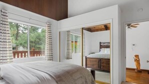 Un dormitorio con una cama grande, cabecera de madera y vistas al exterior a través de una ventana.