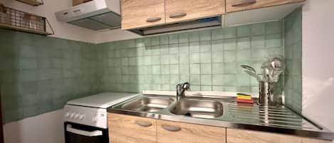 Frigorífico, placa de cocina y utensilios de cocina