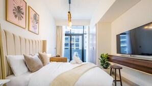 Et moderne hotelværelse med en stor seng, et fjernsyn og udsigt over byen.