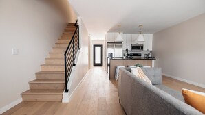 A modern kitchen with white cabinets, stainless steel appliances, and pendant lighting. - -The Cotton House- Modern, Clean, Close to MSU! (Mankato)
