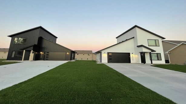 A modern residential area with two houses, each with a garage and a well-maintained lawn. - -The Cotton House- Modern, Clean, Close to MSU! (Mankato)