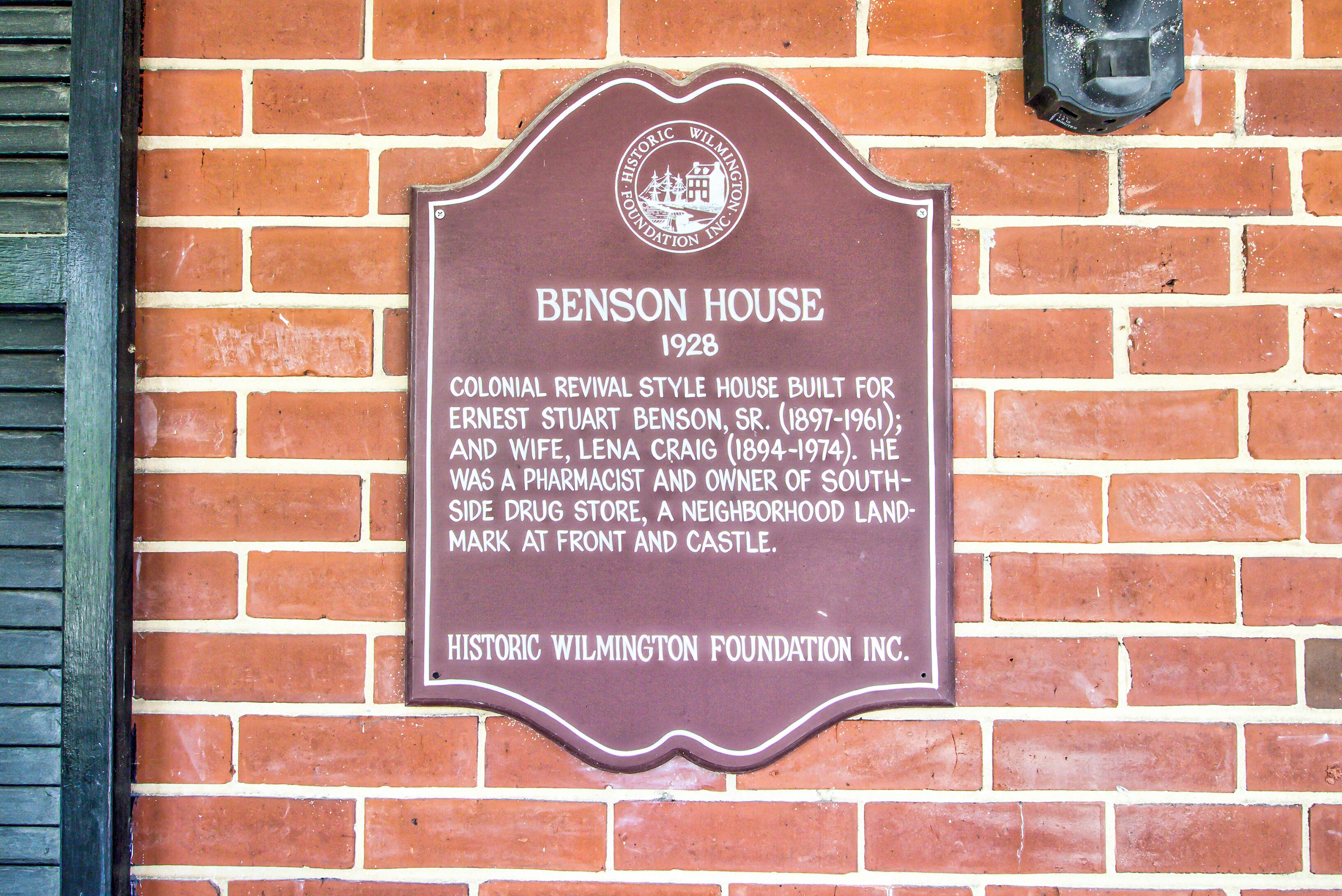 Une plaque commémorative fixée à un mur de briques.