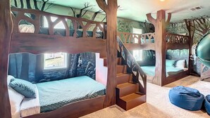 Ein Zimmer mit Etagenbetten, einer Treppe und einem blauen Sitzsack.